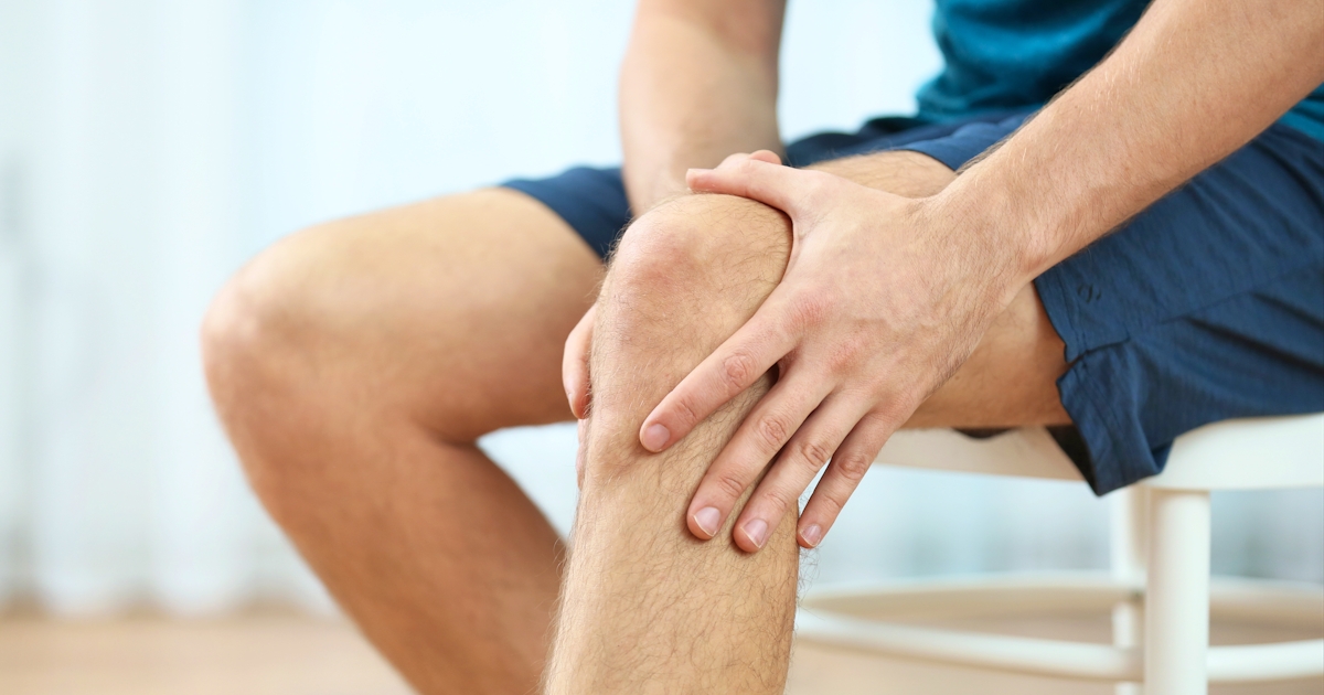 Young man holding knee